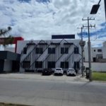 vista exterior panoramica de edificio de oficinas corporativas en renta y venta sobre eje metropolitano león gto con estacionamiento frontal.